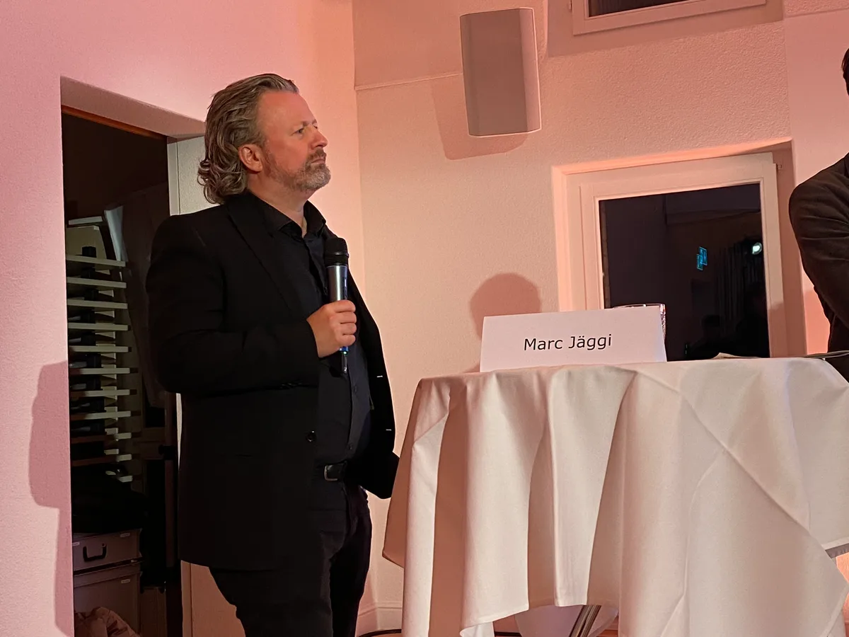 Menschen stehen hinter Stehpulten und führen eine Podiumsdiskussion.
